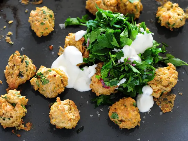 In this image we can see a tray containing snacks and sauce.