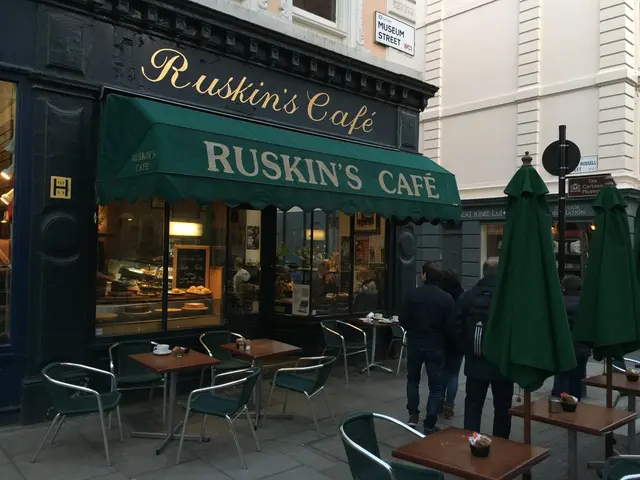In the image we can see there are people who are standing and beside there is a cafe on which it's...